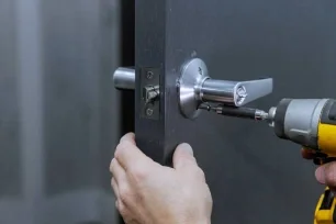 Locksmith drilling and fitting a new lock cylinder on a home exterior door